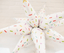 Star-shaped pillow with colorful sprinkles on a light background