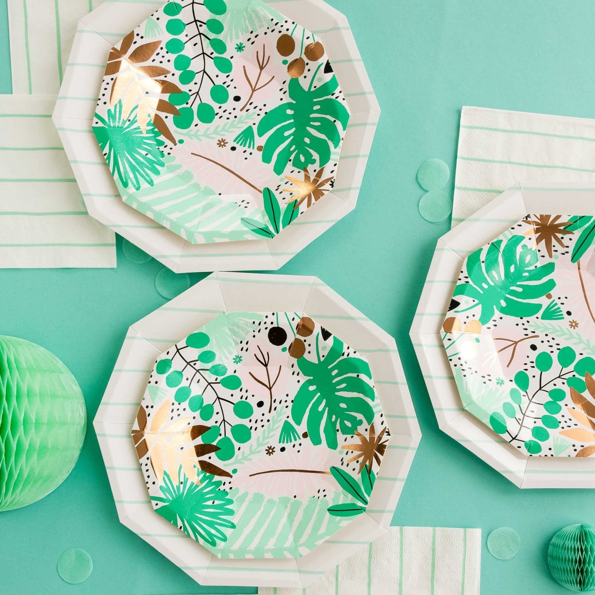 Hexagonal paper plates with green leaf patterns on a teal background