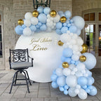 Balloon arch with blue, white, and gold balloons in front of a building entrance.