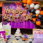 Halloween-themed birthday party setup with balloons, cake, and decorations.