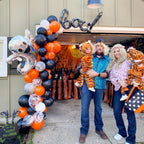 Family with children in tiger costumes standing in front of a decorated truck for Halloween.