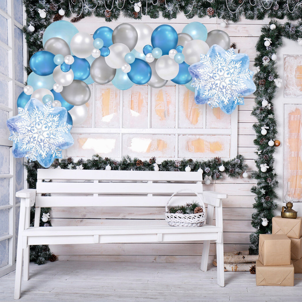 Decorative setup with balloons, snowflakes, and a bench in a festive setting.