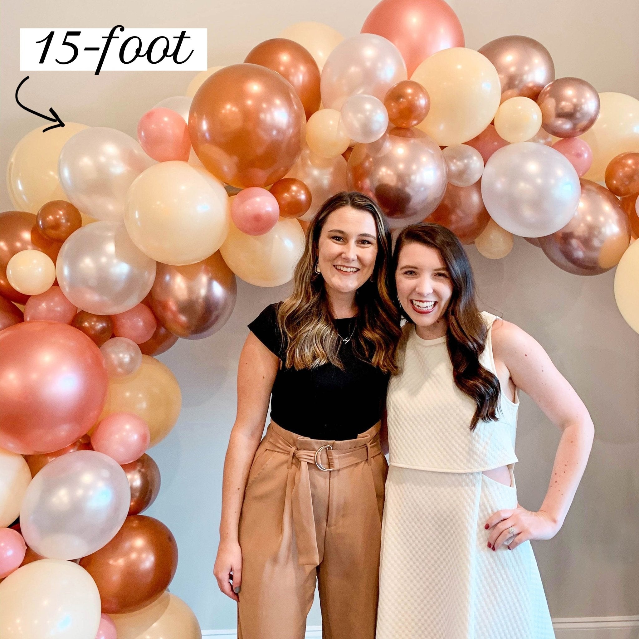 Two women standing in front of a large balloon arch with '15-foot' text above.