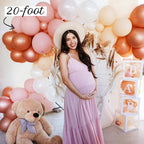 Pregnant woman in a pink dress surrounded by balloons and a teddy bear, with '20-foot' text.