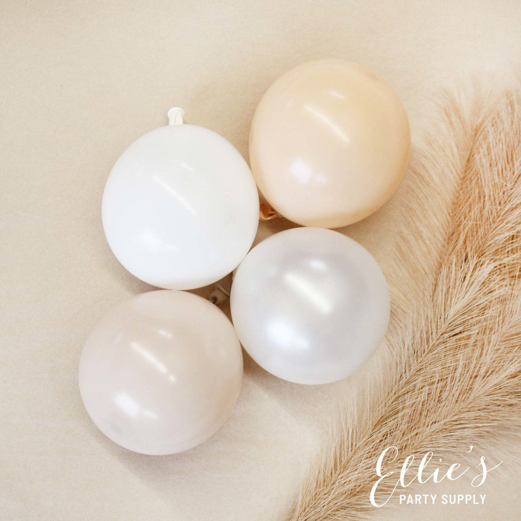 Four white balloons on a beige surface with a feather, branded 'PartyAtOurs'.