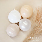 Four white balloons on a beige surface with a feather, branded 'PartyAtOurs'.
