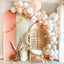Decorative Balloon Garland with a wicker chair and pink wall in a room.