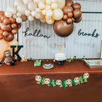 Decorative setup with balloons, cake, and sloth-themed decorations on a table.