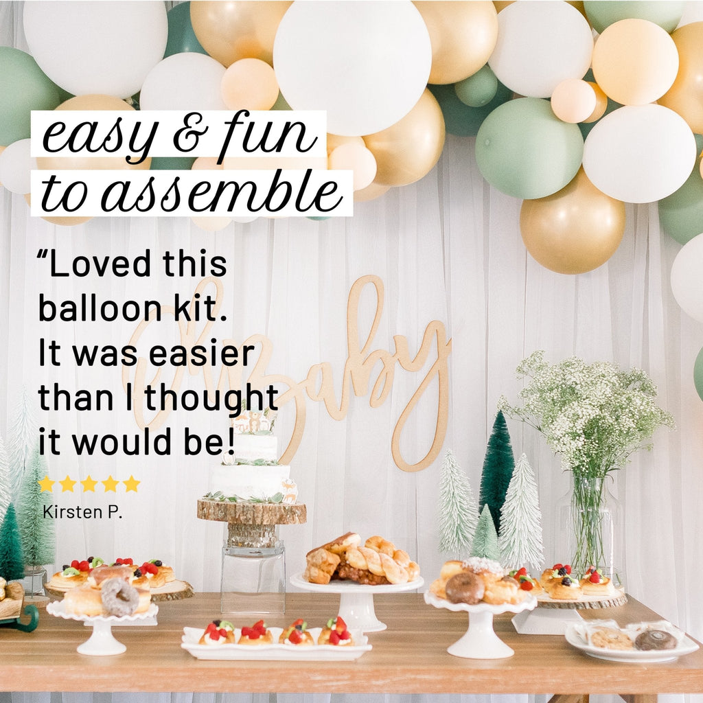 Decorated baby shower table with balloons and centerpieces, featuring a 'Baby' sign.