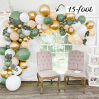 Balloon arch with green, gold, and white balloons in a room with two chairs.