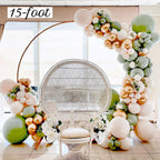 Balloon arch with flowers and a wicker chair in a room.
