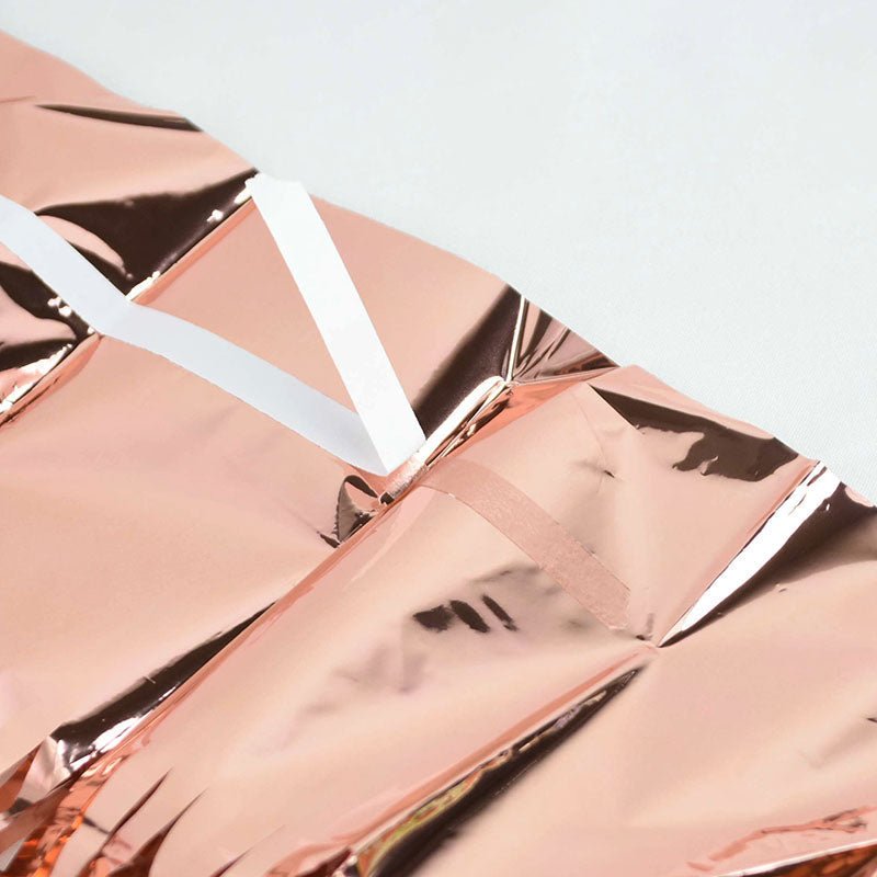 Rose gold metallic packaging with white accents on a light gray background
