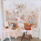 Room with a Peter Rabbit photo backdrop mural of animals and a wooden chair.