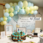 Birthday party setup with balloons, cake, and cupcakes in a room with Winnie the Pooh decorations.