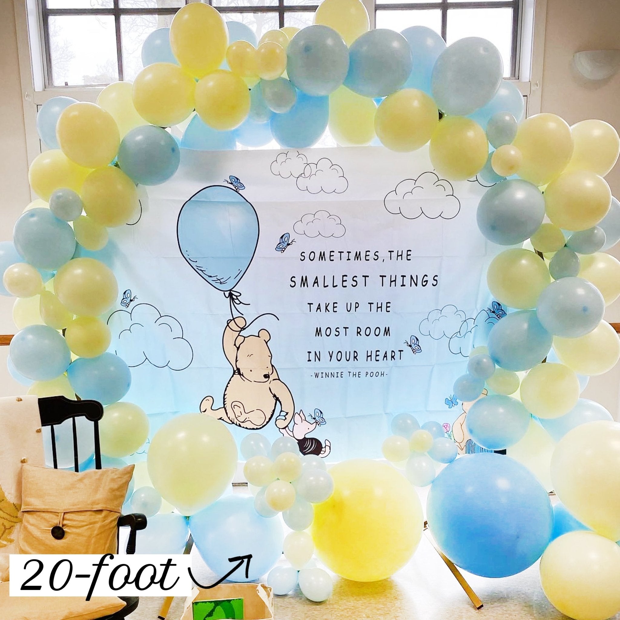 Balloon arch with Winnie the Pooh and balloons, featuring a quote.