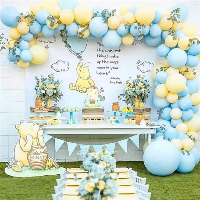 Decorated outdoor space with Winnie the Pooh theme, balloons, and floral arrangements.