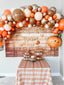 Decorative setup with balloons, a wooden backdrop, and a table with treats.