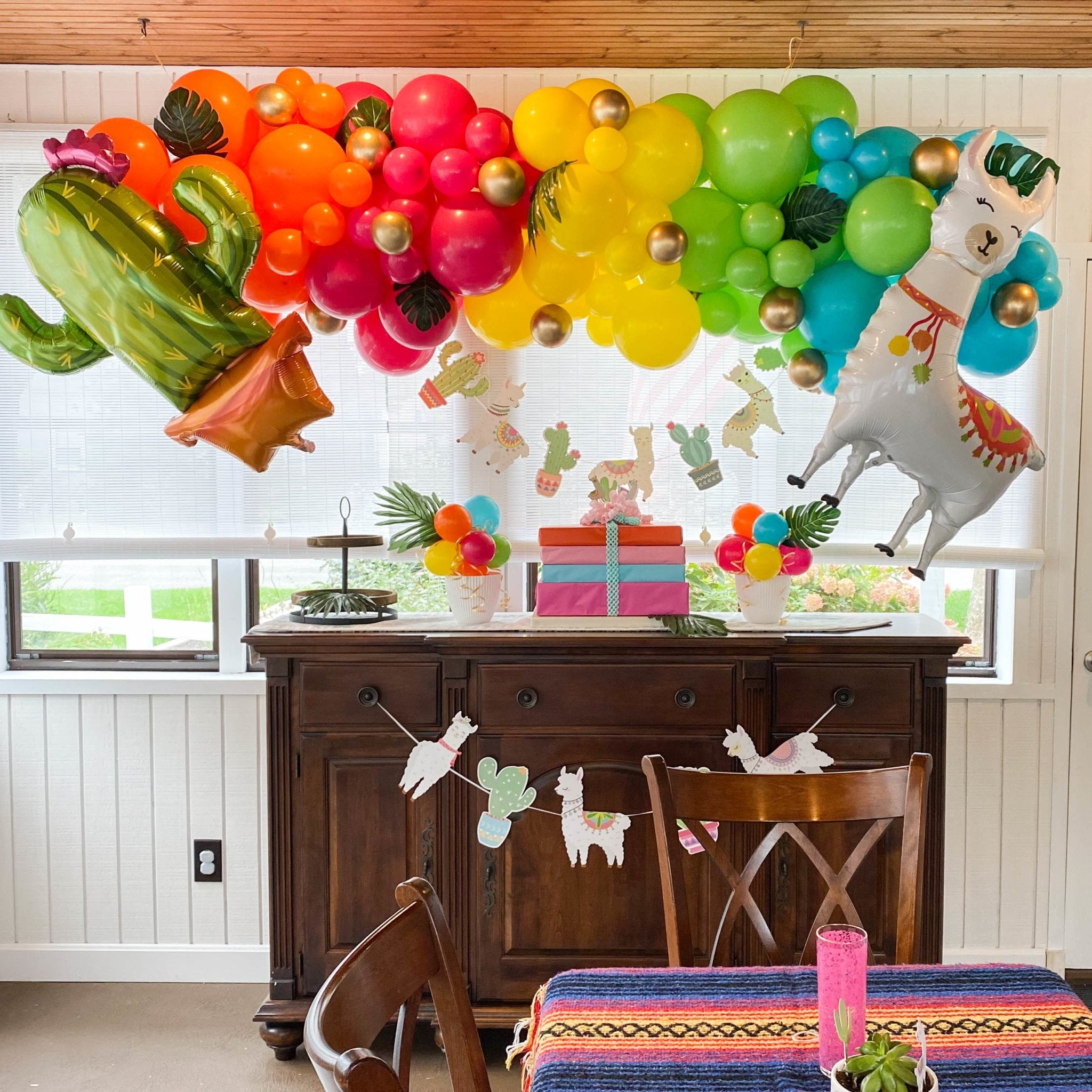 Decorated room with colorful balloons, a cactus balloon, and festive decorations.