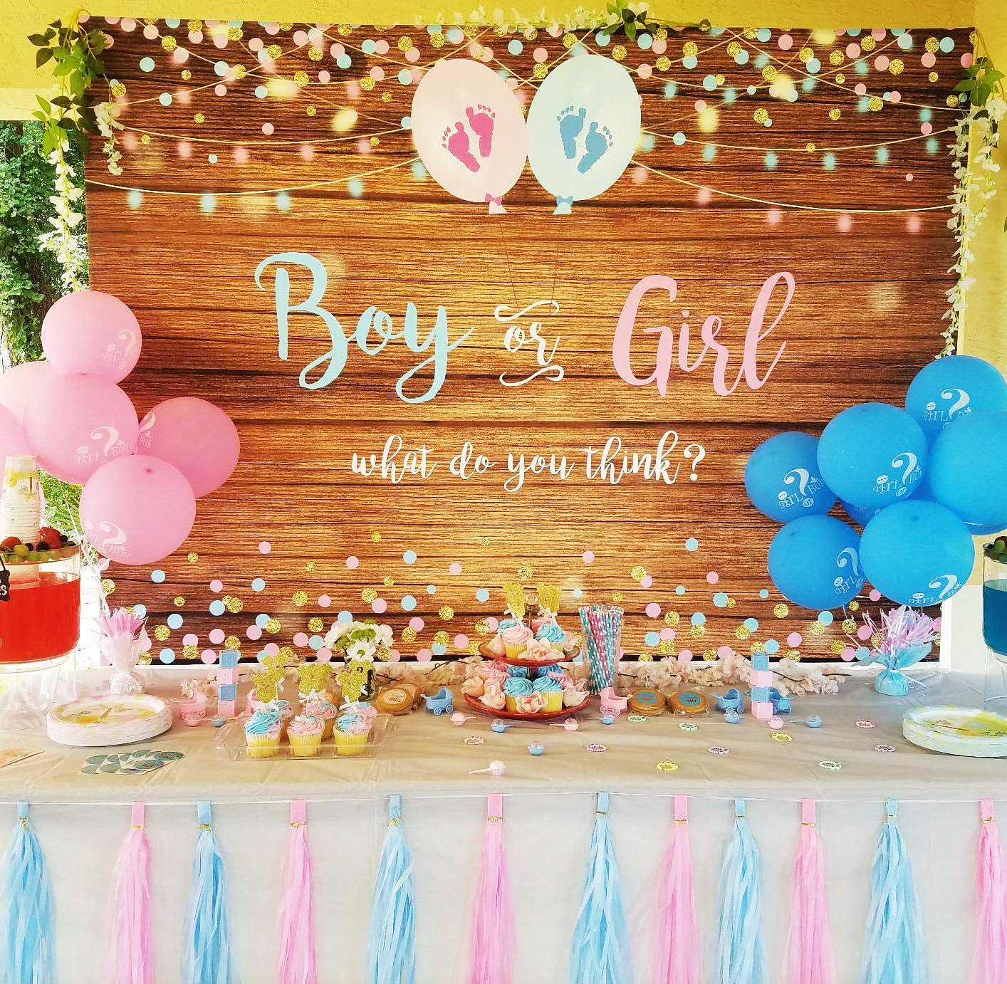 Gender reveal party setup with 'Boy or Girl' sign and balloons.