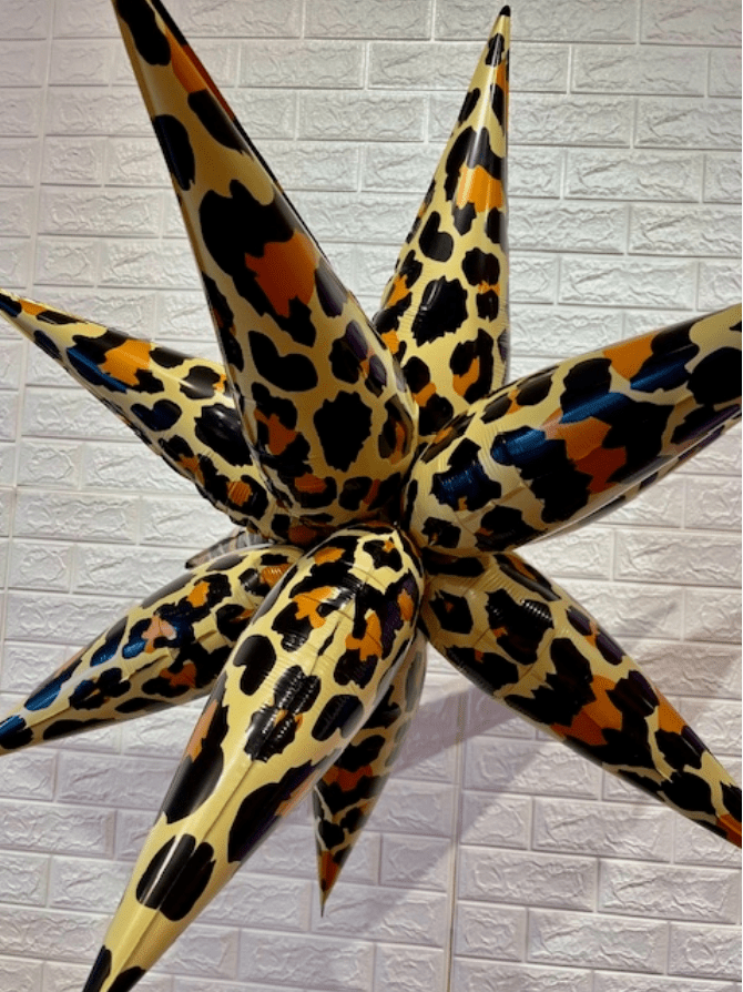 Leopard print inflatable star against a textured wall. Main image