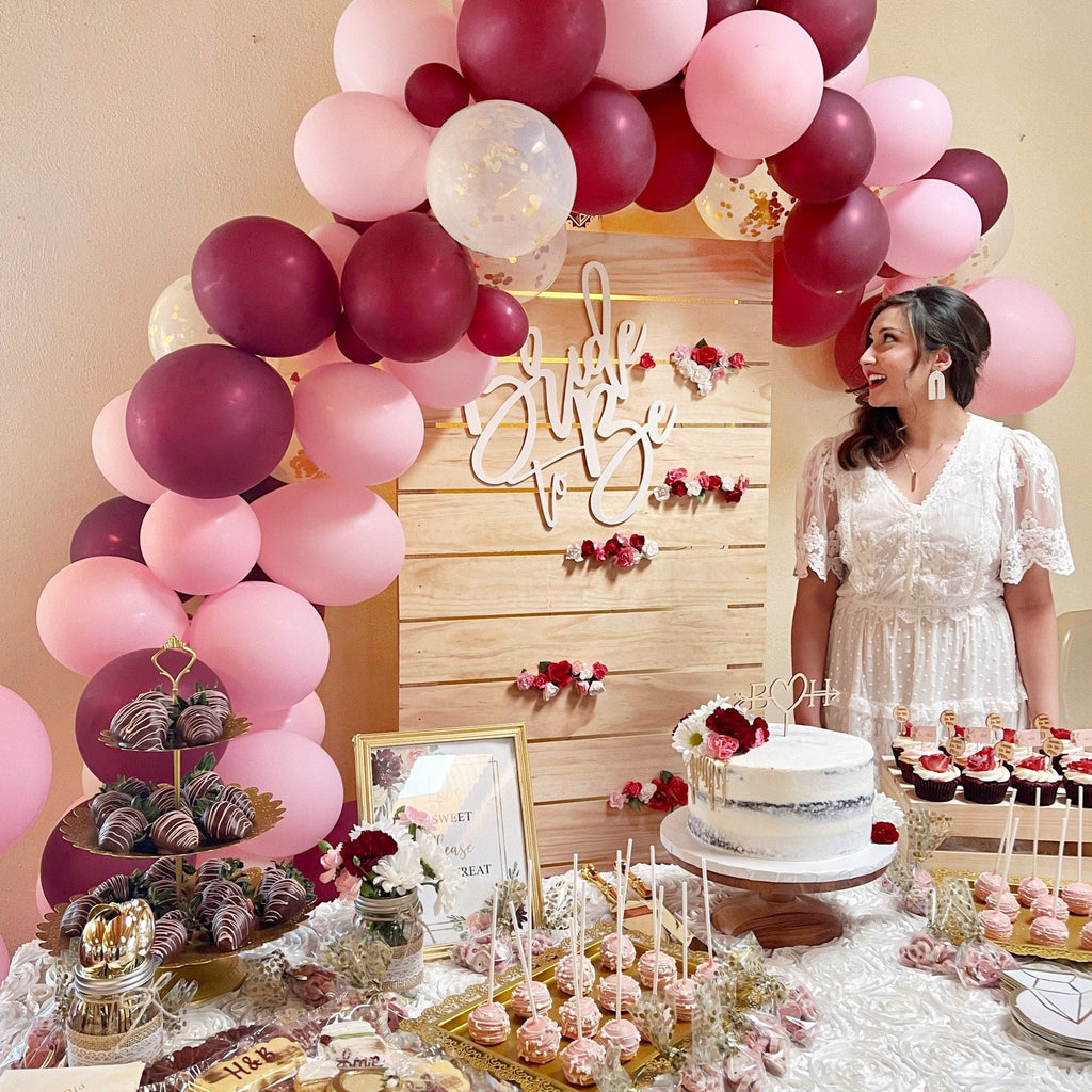 Decorated birthday party with balloons, cake, and sweets in a room.