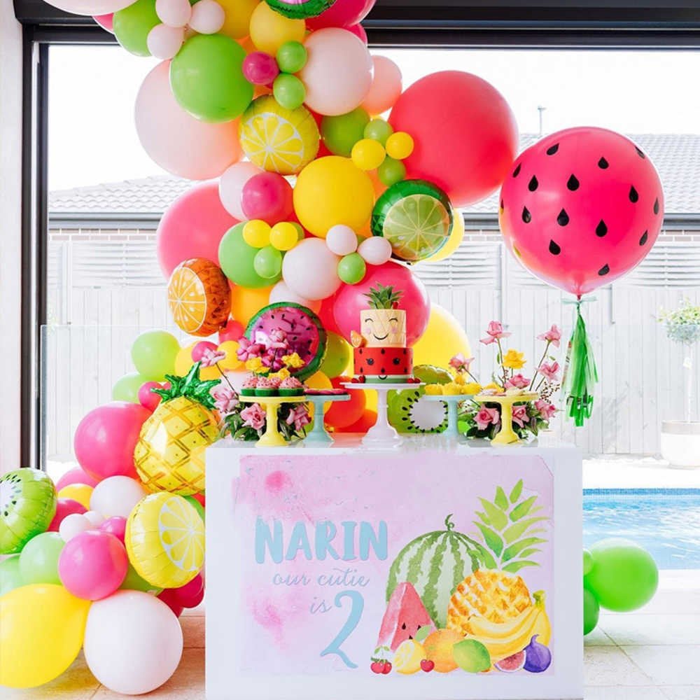 Colorful balloon arch with fruit-themed decorations and a birthday sign.