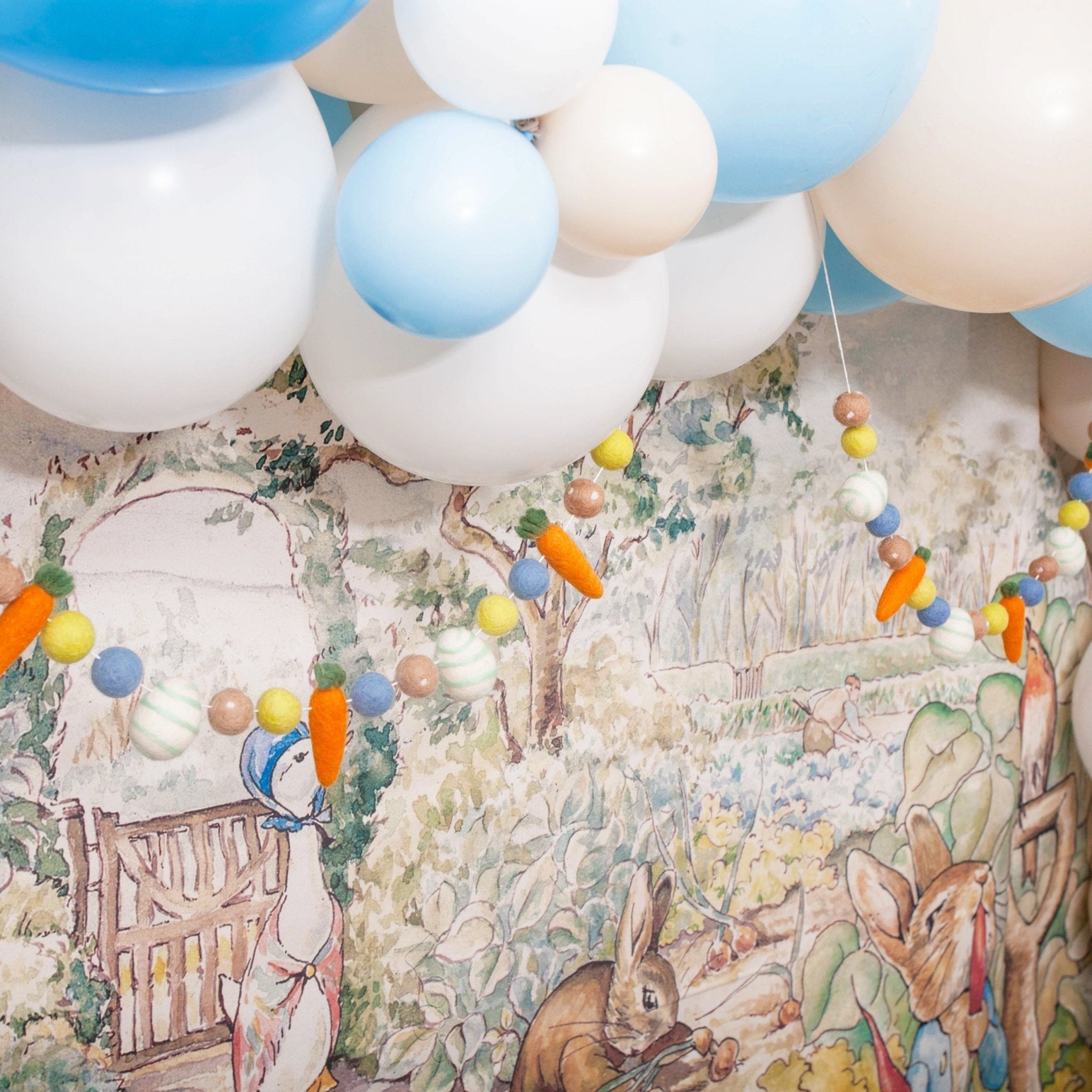 Decorative backdrop with cartoon characters and balloons in a garden setting