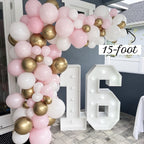 Balloon arch with pink, gold, and white balloons and a large '16' sign in a room.