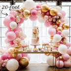 Balloon arch with pink, gold, and white balloons above a dessert table.