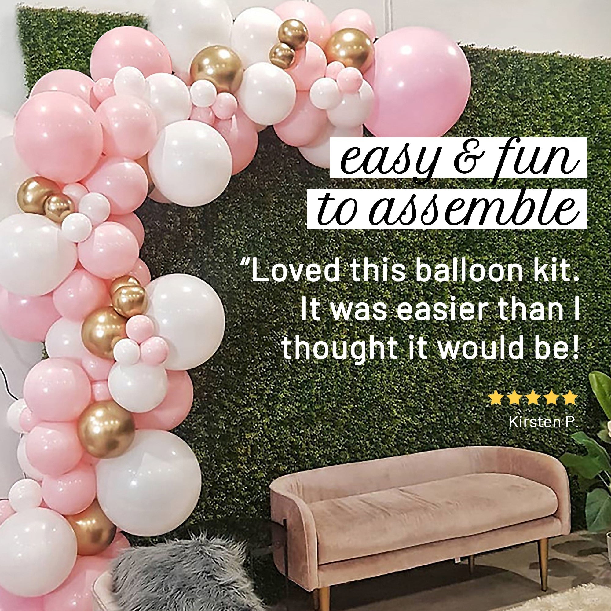 Balloon arch with pink, white, and gold balloons against a green wall with a couch underneath.
