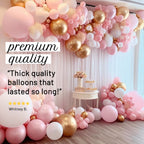Pink, gold, and white balloon arch with decorative elements and text on a light background