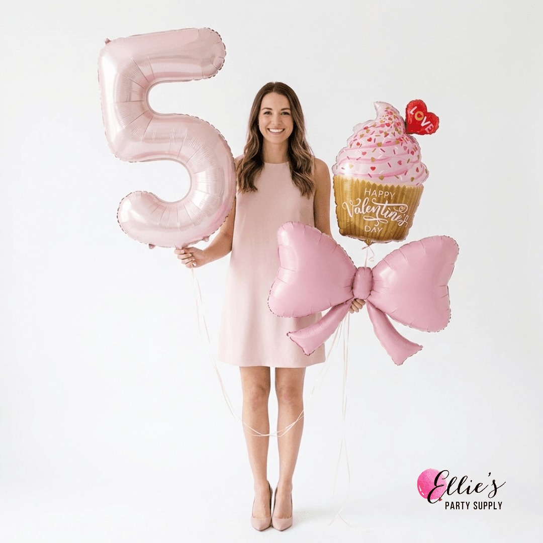 Woman in a pink dress holding a large pink number 5 balloon and a cupcake with a bow, against a white background.