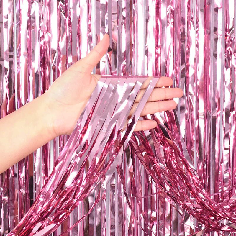 Pink metallic curtain backdrop with a hand holding it