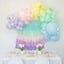 Pastel balloon arch with a table set for a celebration.