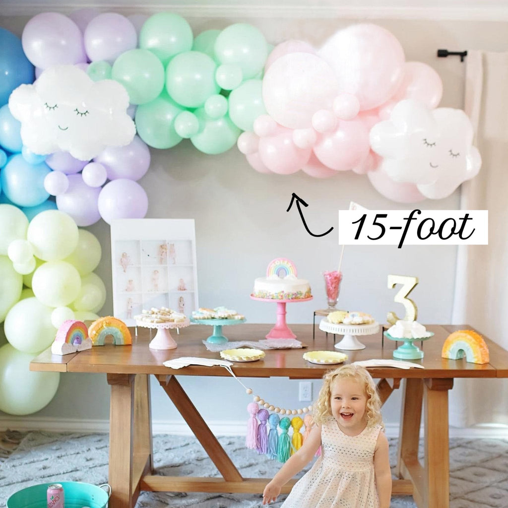 Child's birthday party setup with balloons, cake, and decorations in a room.