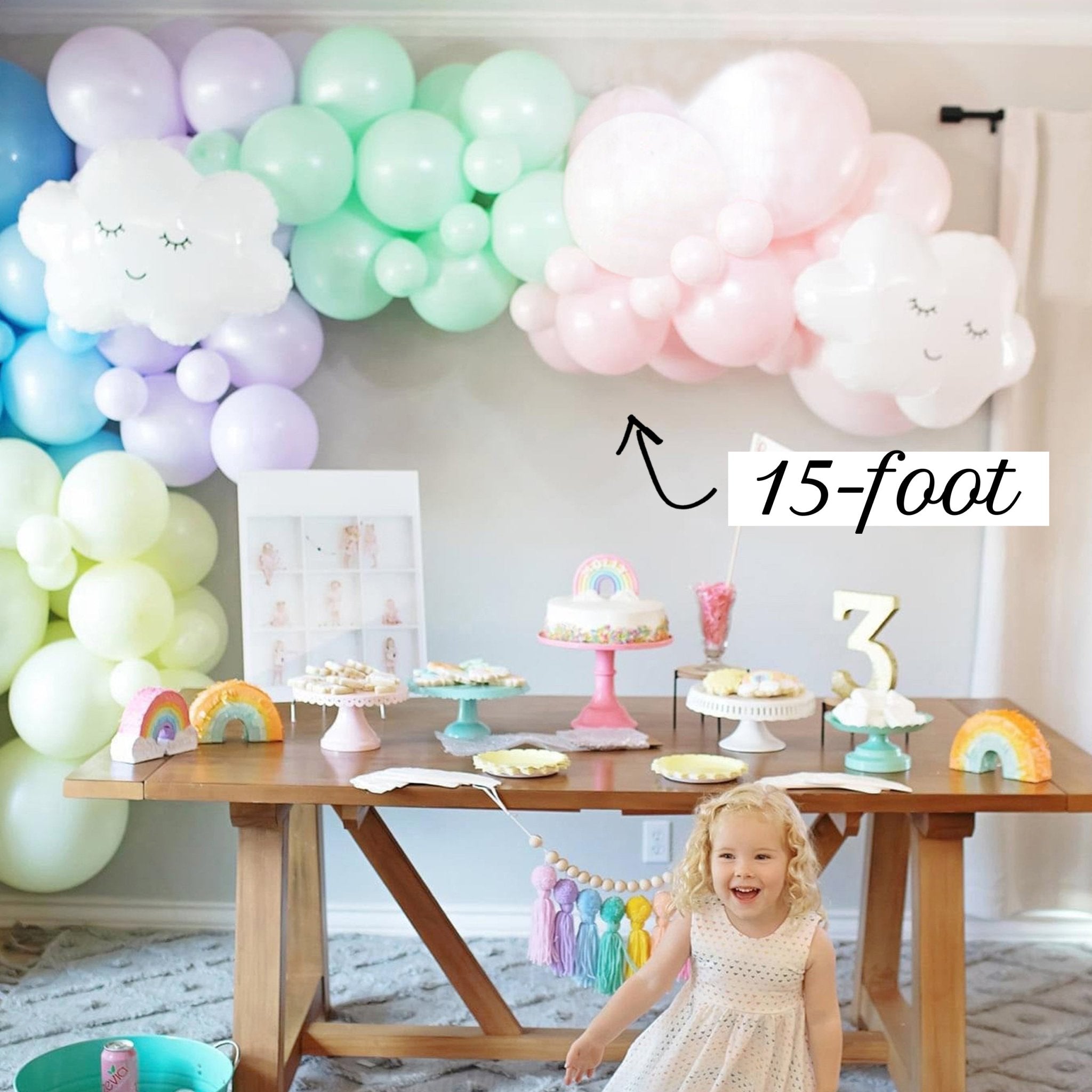 Child's birthday party setup with balloons, cake, and decorations in a room.