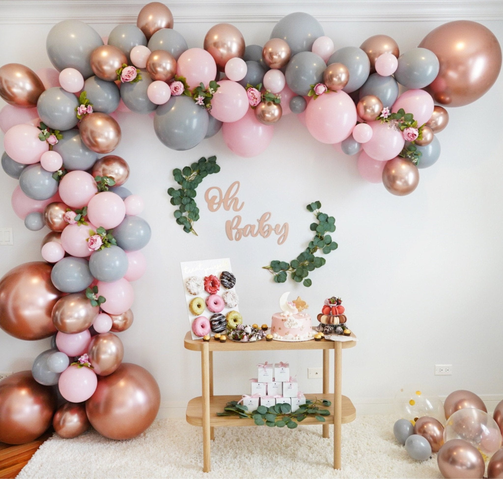 Balloon arch with pink, gray, and rose gold balloons, 'Oh Baby' sign, and dessert table. Main image