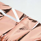 rose gold tinsel curtain with white accents on a light gray background