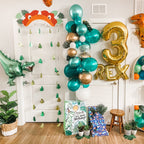 Dinosaur-themed birthday party setup with balloons, decorations, and a '3 Rex' sign.