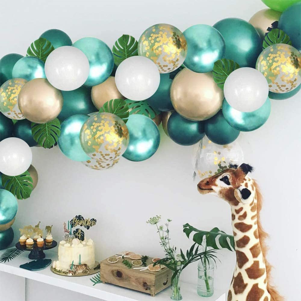 Balloon arch with teal, white, and gold balloons in a room with a giraffe decoration.