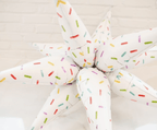 Star-shaped pillow with colorful sprinkles on a light background