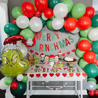 Decorated room with balloons, 'Merry Grinchmas' sign, and Grinch-themed table setting.
