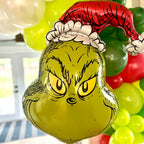 Balloon shaped like the Grinch with a red hat and white gloves, surrounded by other balloons.