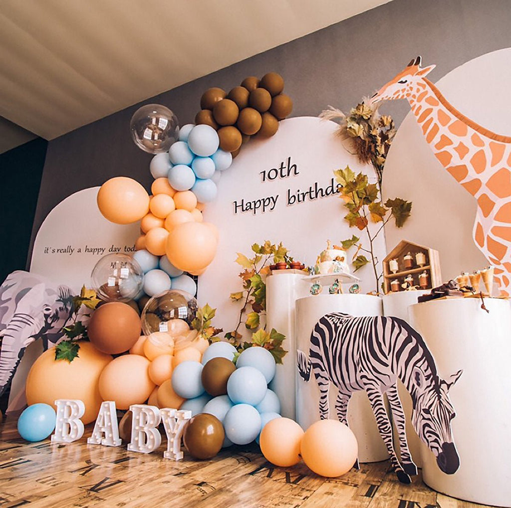 Birthday celebration setup with balloons, cake, and animal decorations.
