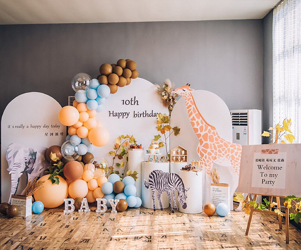 Birthday party setup with balloons, a giraffe decoration, and '10th Happy Birthday' sign.
